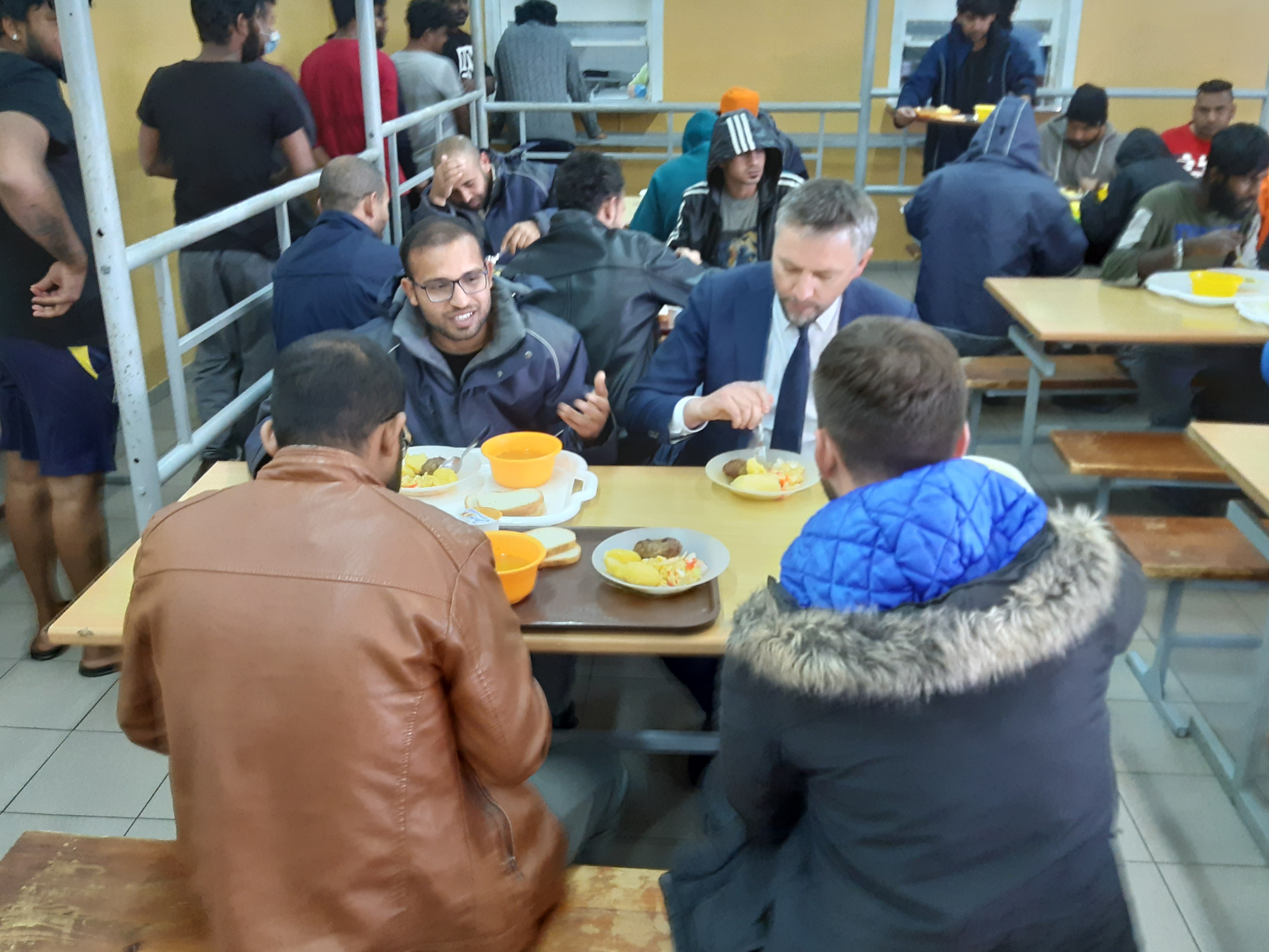 Už grotų atsidūrę migrantai atvykusius parlamentarus pasitiko baisiais priekaištais: Seimo nariui teko ragauti jų maisto